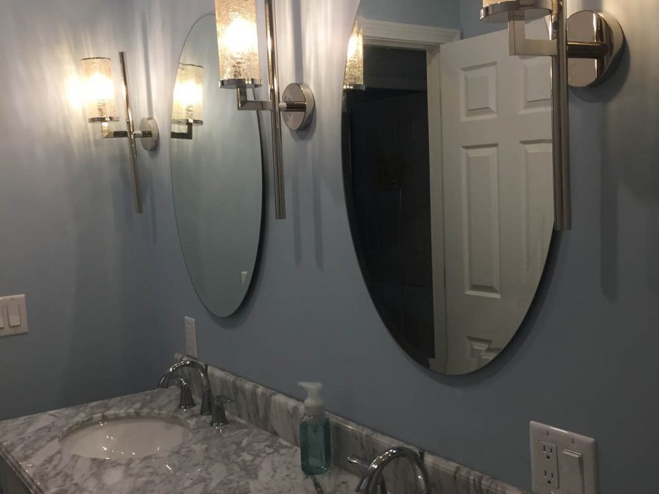 Custom light fixtures on the wall in a Cape Cod bathroom